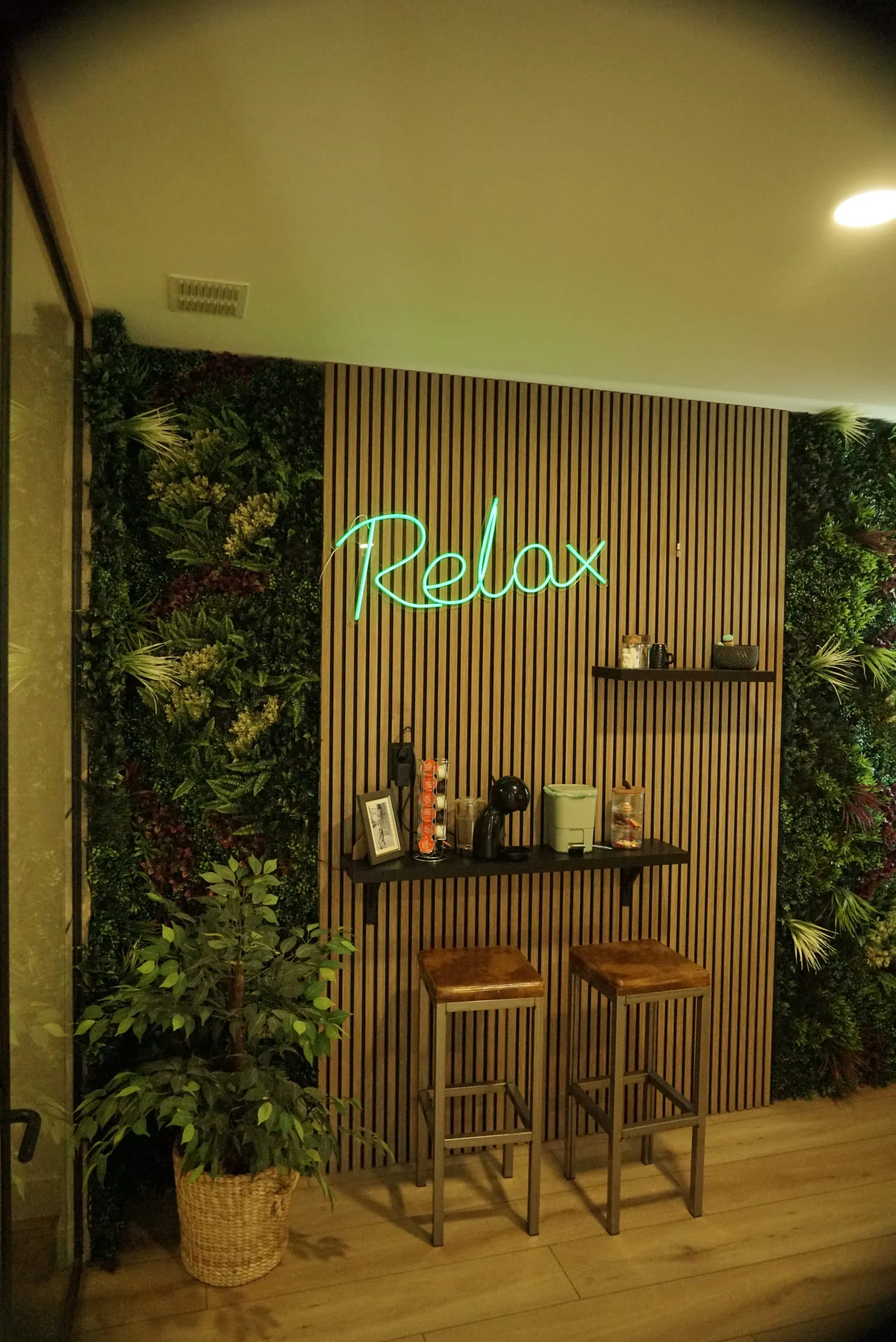 De plantenwand met het neonwoord Relax