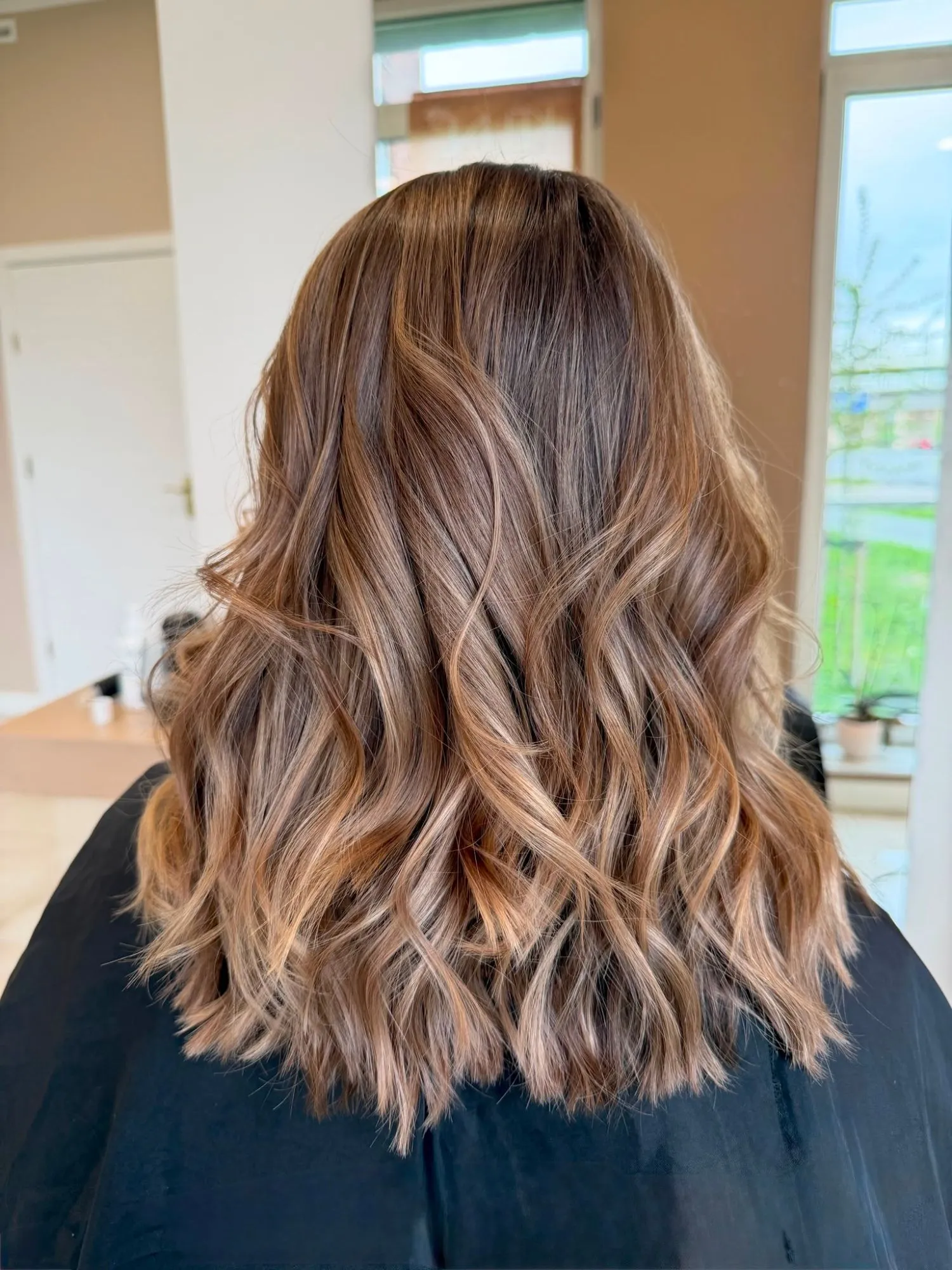 Balayage in warme karameltinten met losse golven, middellang haar